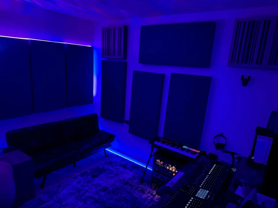 Lunar Mansion Studios control room lounge area with leather couch, keyboard, and acoustic panels